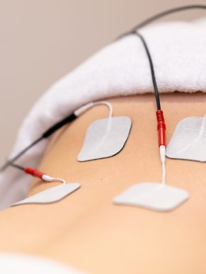 Electro stimulation in the lumbar zone in physical therapy to a young woman in a physiotherapy center.